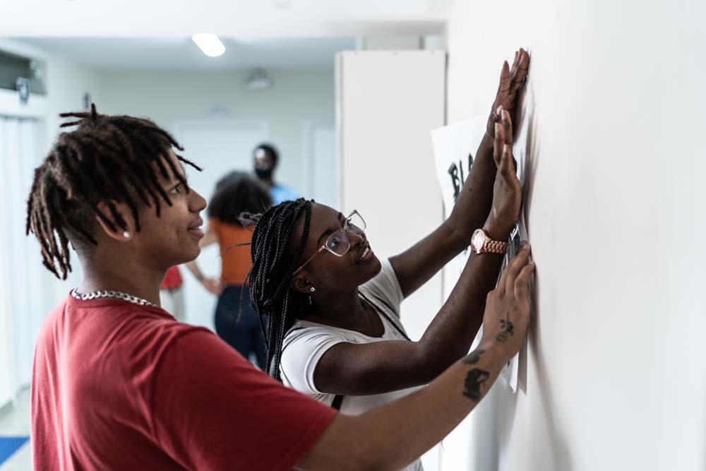 People with ethnic background pining up plans on wall.